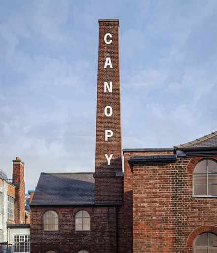 Canopy vertical wordmark applied to the brickwork of the chimney